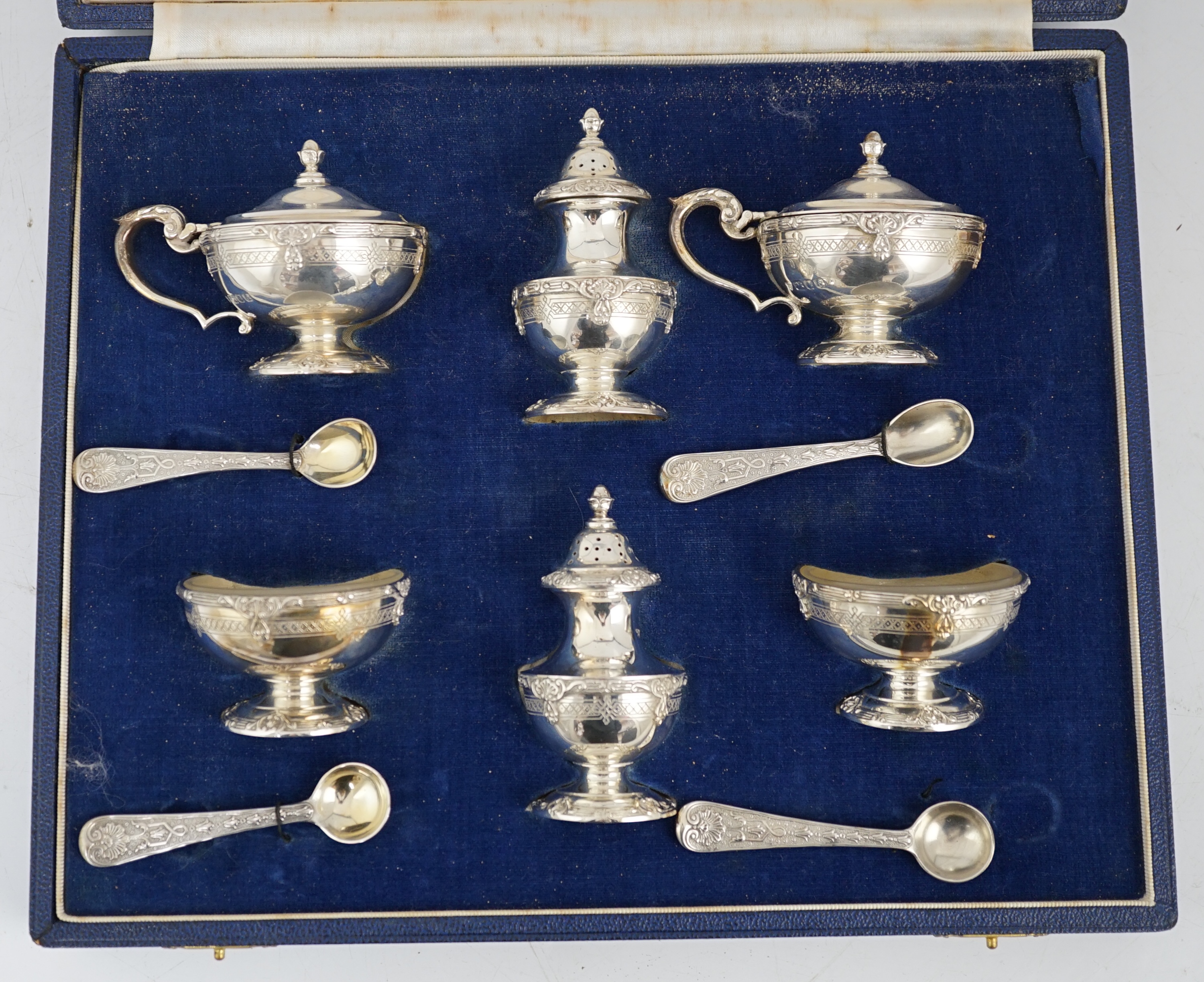 An Elizabeth II cased silver six piece pedestal condiment set, with four matching spoons, by Garrard & Co